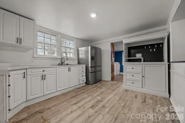 a kitchen with white cabinets and sink