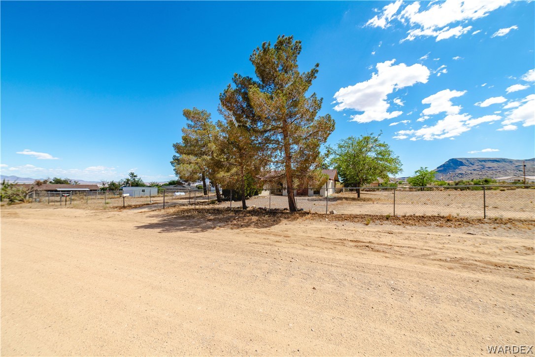 2100 East Valley View Road Kingman, AZ 86409 - Photo 53 of 53 Expansive land parcel featuring a gravel-like ground cover, mature trees, and a distant mountain backdrop