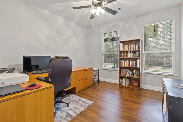a view of a workspace with furniture and a window