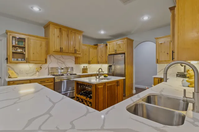 a kitchen with stainless steel appliances granite countertop a sink stove and refrigerator