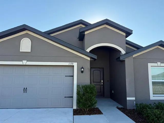 a front view of a house with plants