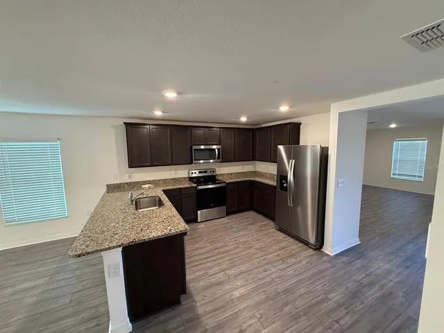 a kitchen with stainless steel appliances granite countertop a refrigerator and a sink
