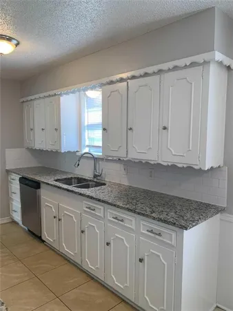 a kitchen with granite countertop white cabinets and white appliances