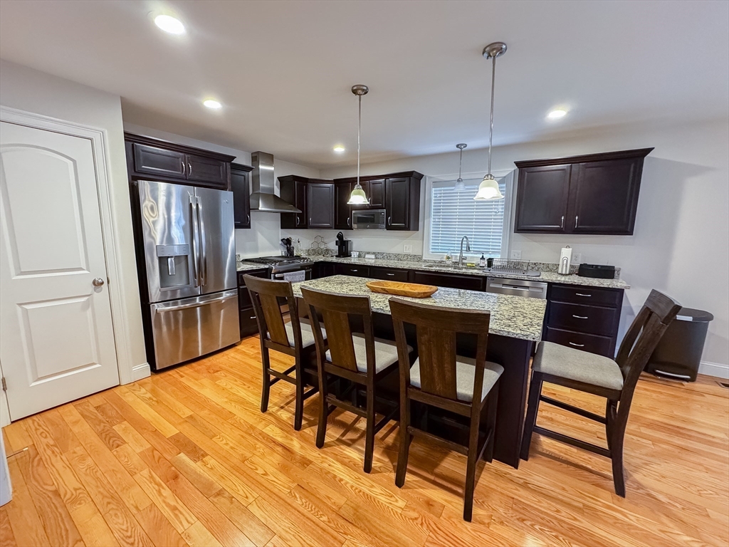 23 Ralph Street Chicopee, MA 01020 - Photo 3 of 42 a kitchen with stainless steel appliances granite countertop a table chairs refrigerator and microwave