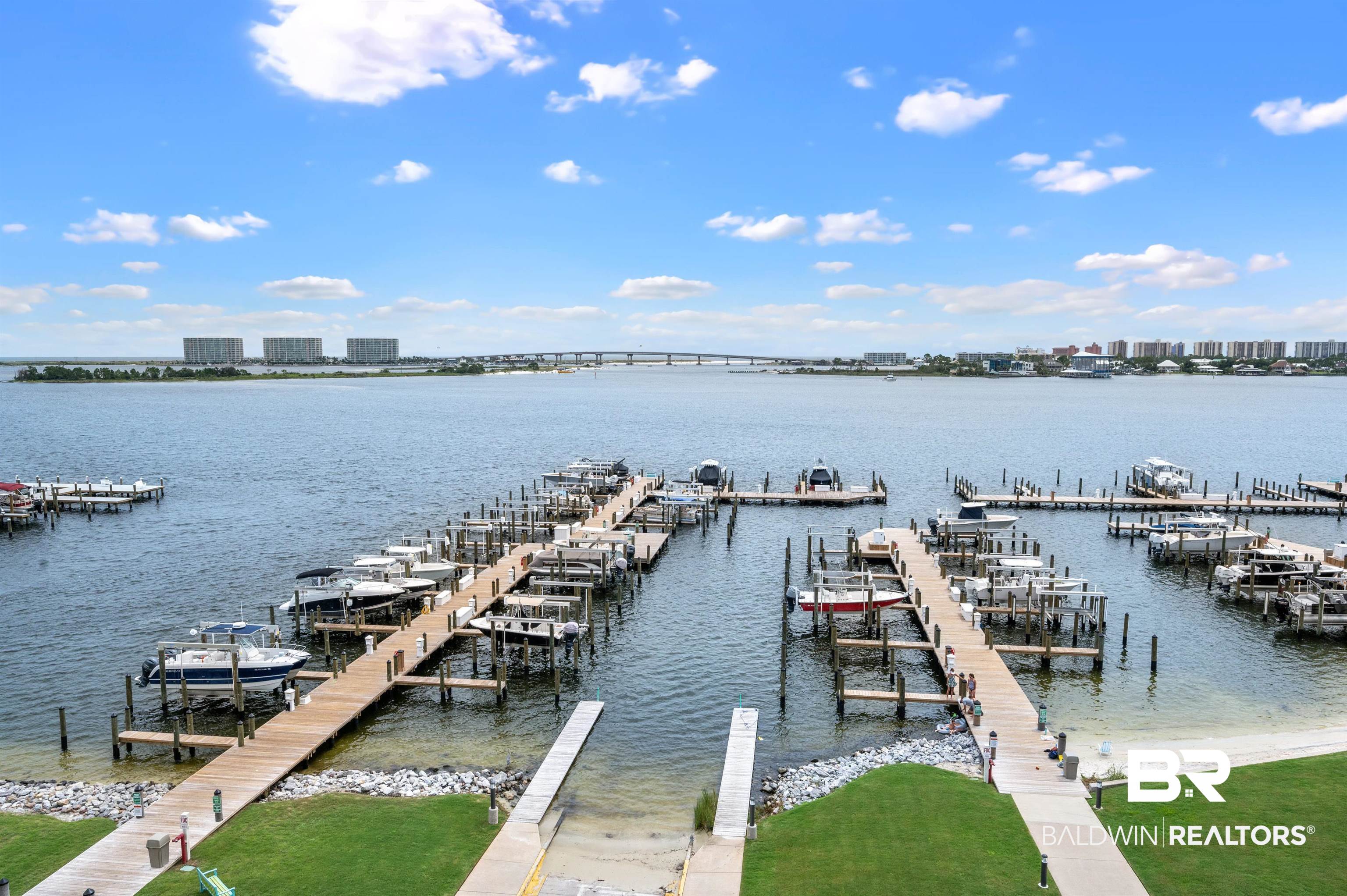 27580 Canal Road, Unit 1421 Orange Beach, AL 36561 - Photo 8 of 40 Marina featuring multiple boat slips, immediate water access, a sandy shore, and manicured green spaces