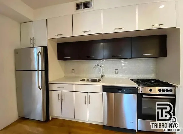 a kitchen with stainless steel appliances a stove microwave and sink