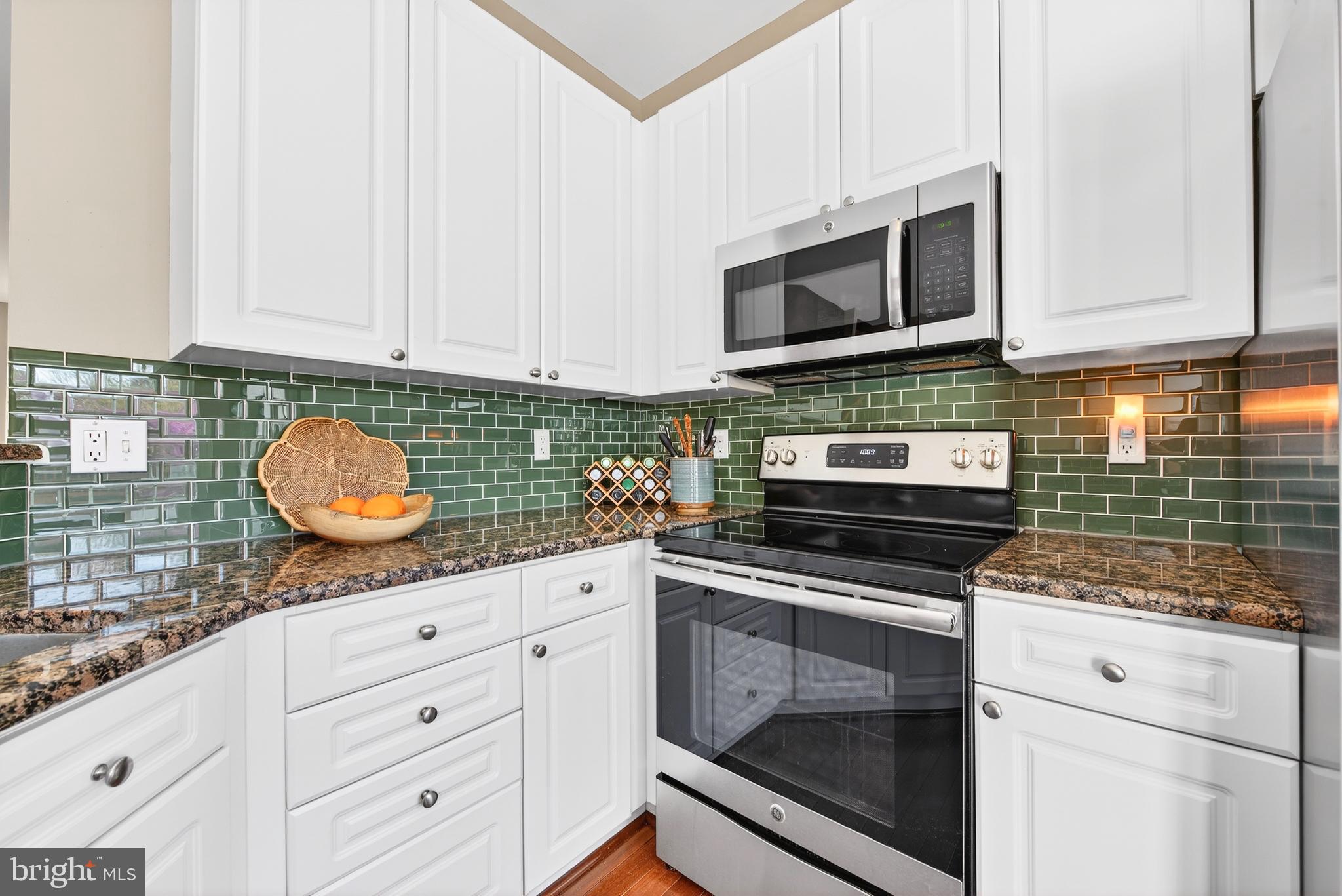 12017 Edgemere Circle Reston, VA 20190 - Photo 14 of 30 a kitchen with granite countertop white cabinets stainless steel appliances and wooden floor