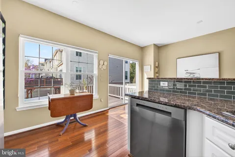 a living room with granite countertop furniture a rug wooden floor and a large window