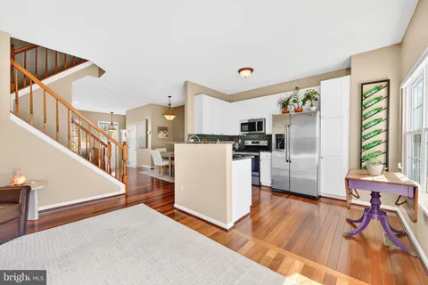 a kitchen with stainless steel appliances a refrigerator and a wooden floor