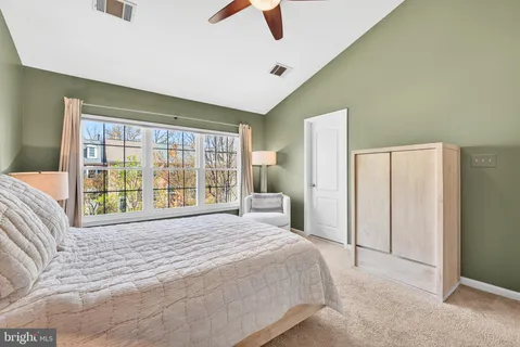 a bedroom with a bed and a large window