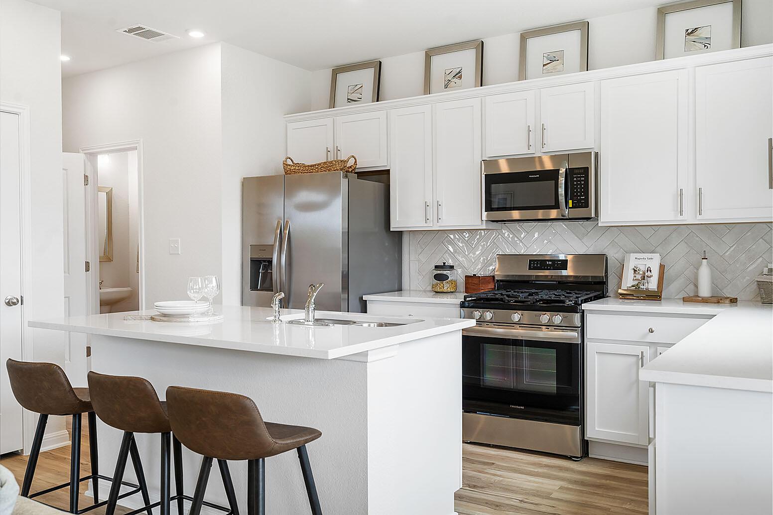 20603 B Combine Path Pflugerville, TX 78660 - Photo 4 of 19 A pristine culinary space boasts an eat-in island, stainless steel appliances, and sleek countertops.