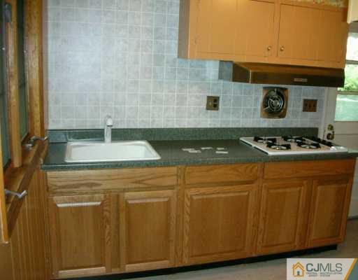 210 Princeton Road Old Bridge, NJ 08859 - Photo 3 of 8 a kitchen with granite countertop cabinets and black appliances