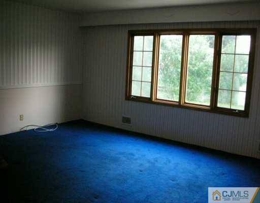 210 Princeton Road Old Bridge, NJ 08859 - Photo 5 of 8 an empty room with wooden floor and windows