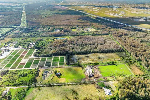 an aerial view of a house with a garden and lake view