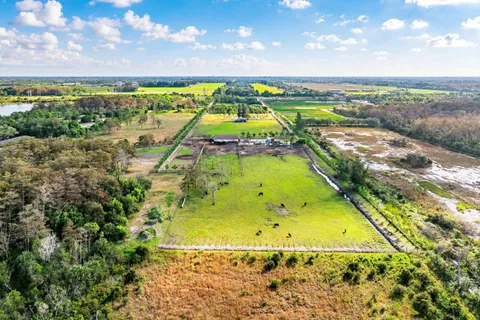 an aerial view of a house with a garden and lake view