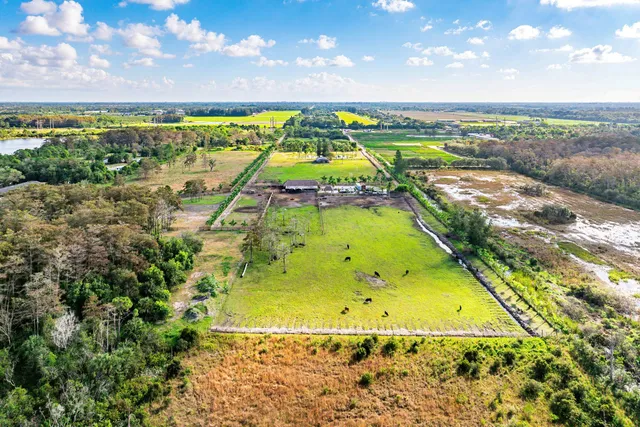 an aerial view of a house with a garden and lake view