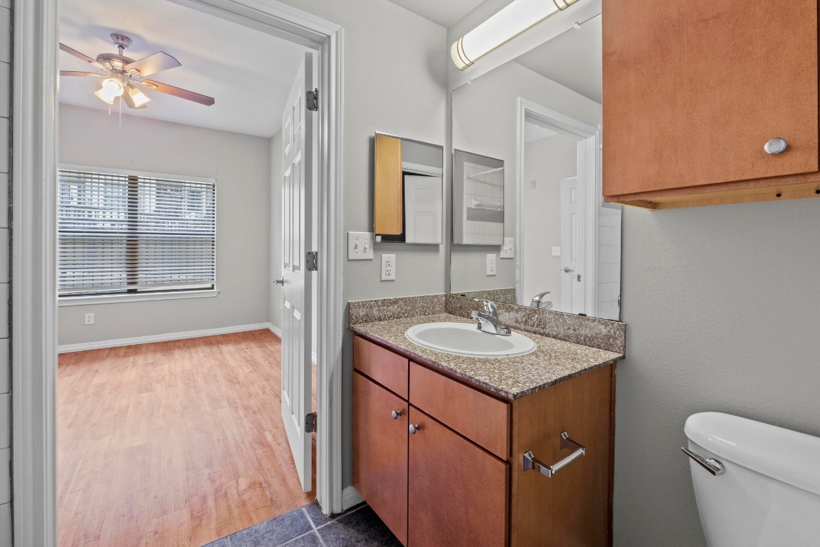 2502 Leon Street, Unit 213 Austin, TX 78705 - Photo 13 of 20 Half bathroom with vanity, ceiling fan, and dark wood finished floors