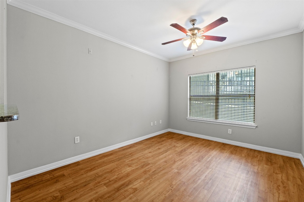 2502 Leon Street, Unit 213 Austin, TX 78705 - Photo 3 of 20 Unfurnished room with crown molding, light wood-type flooring, and a ceiling fan