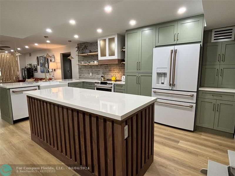 a kitchen with kitchen island a sink stainless steel appliances and cabinets