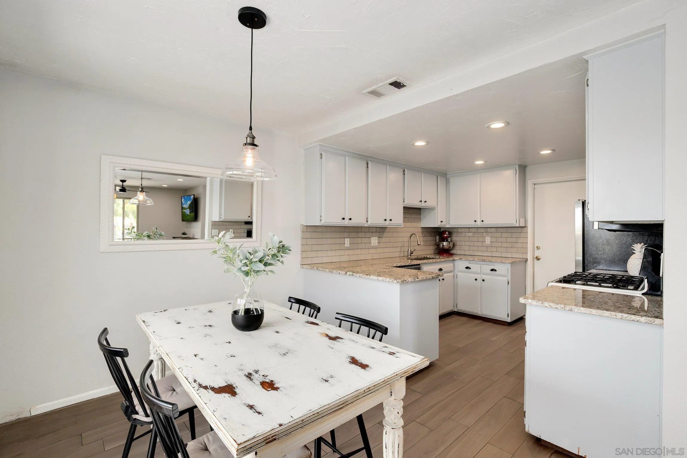 320 Grapevine Road, Unit 15 Vista, CA 92083 - Photo 3 of 18 a kitchen with a dining table chairs refrigerator and cabinets