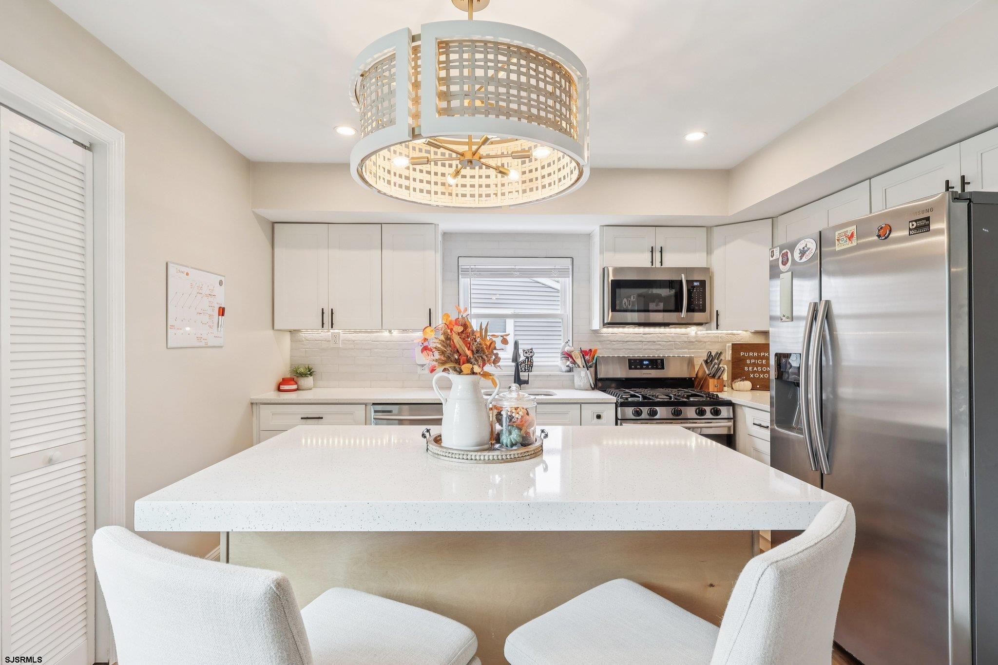13 Gulph Mill Road Somers Point, NJ 08244 - Photo 15 of 43 a kitchen with a dining table and chairs