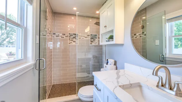 a bathroom with a sink a toilet and shower