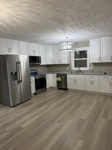 a kitchen with stainless steel appliances a refrigerator sink and microwave