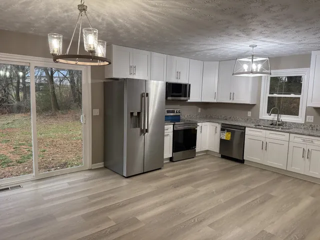 a kitchen with stainless steel appliances a refrigerator sink and cabinets