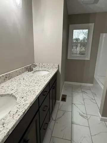 a bathroom with a granite countertop sink and mirror