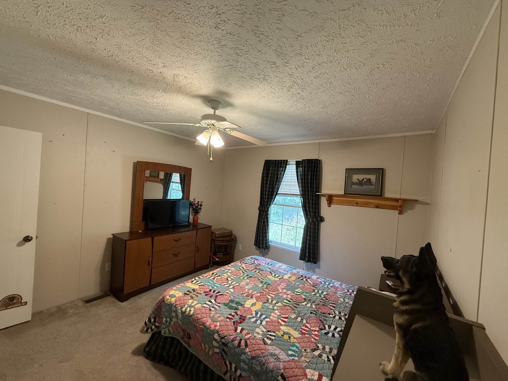 1640 Bucket Branch Road Waverly, TN 37185 - Photo 20 of 38 a bedroom with a bed and a flat tv screen on the dresser