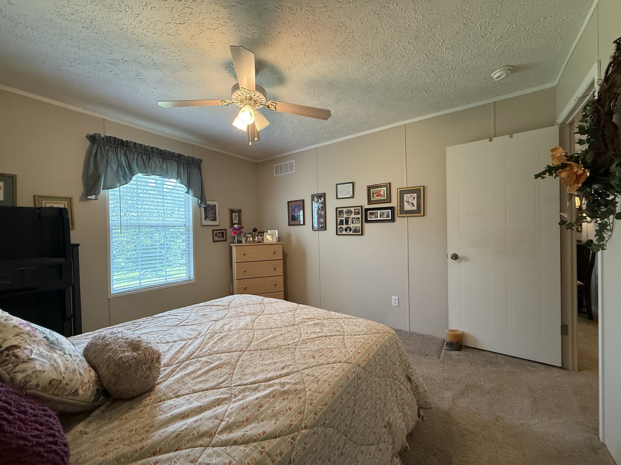 1640 Bucket Branch Road Waverly, TN 37185 - Photo 27 of 38 a bedroom with a large bed and a chandelier
