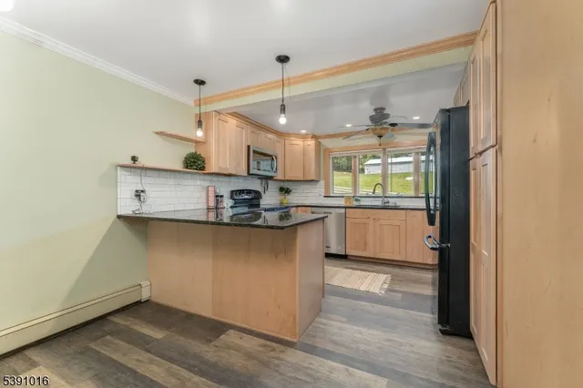 a kitchen with stainless steel appliances granite countertop a sink a stove and a refrigerator