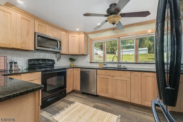 a kitchen with granite countertop a stove sink and microwave