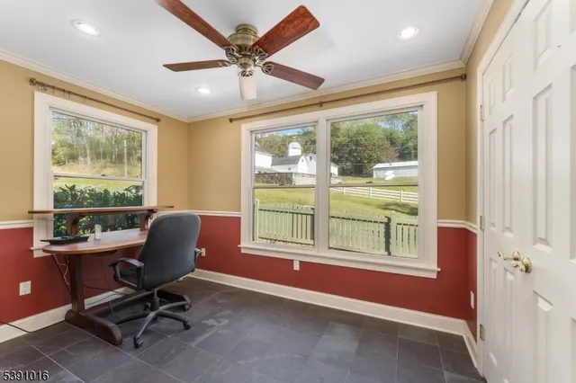 a view of a workspace with furniture and a window