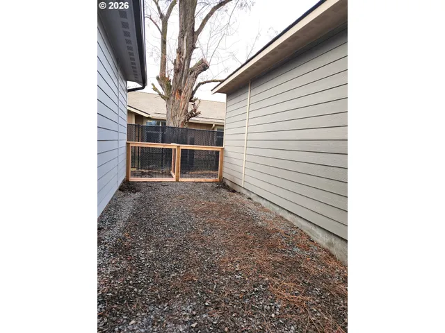 a view of house with backyard and wooden fence