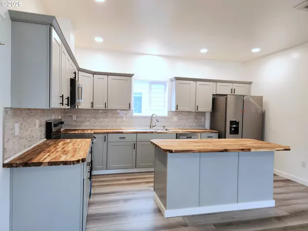 a kitchen with stainless steel appliances granite countertop a sink stove and refrigerator