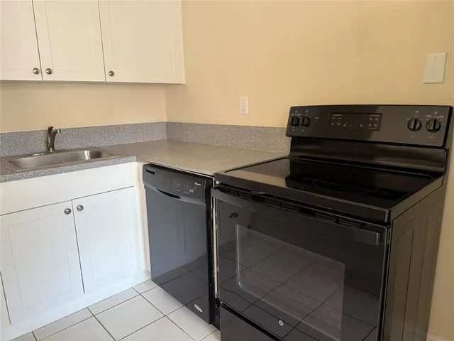 a kitchen with a stove and white cabinets