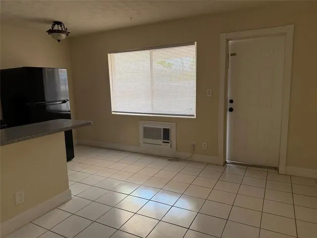 a view of an empty room with window and a fireplace