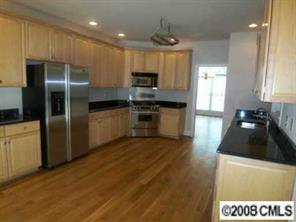 280 Patternote Road Mooresville, NC 28117 - Photo 3 of 8 a kitchen with granite countertop a refrigerator and a stove top oven