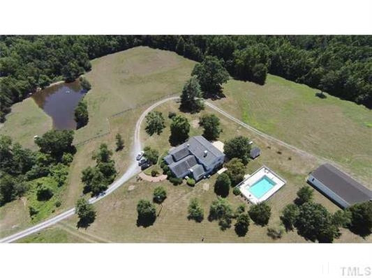 9123 South Lowell Road Bahama, NC 27503 - Photo 3 of 25 This aerial view shows the location of the house and pool, the 5-bay equipment bay and pond. T he 6-stall shed-row barn is not shown in this photo. Aerial view of the farm