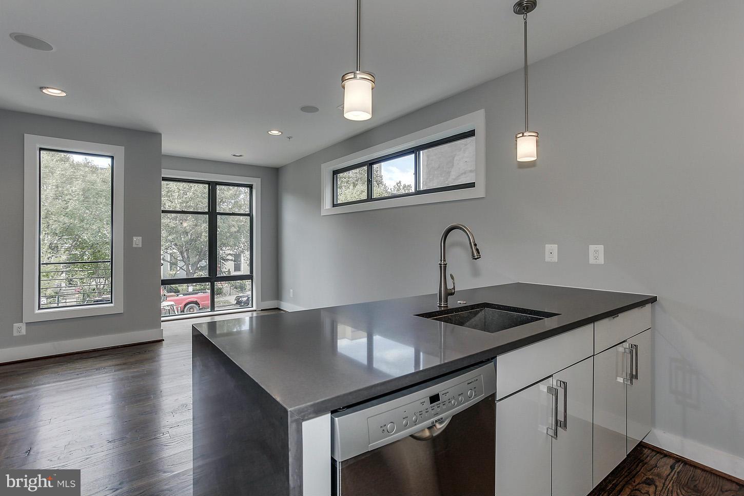 1839 6th Street Northwest, Unit 4 Washington, DC 20001 - Photo 2 of 29 a kitchen with stainless steel appliances granite countertop a sink a stove and a wooden floor