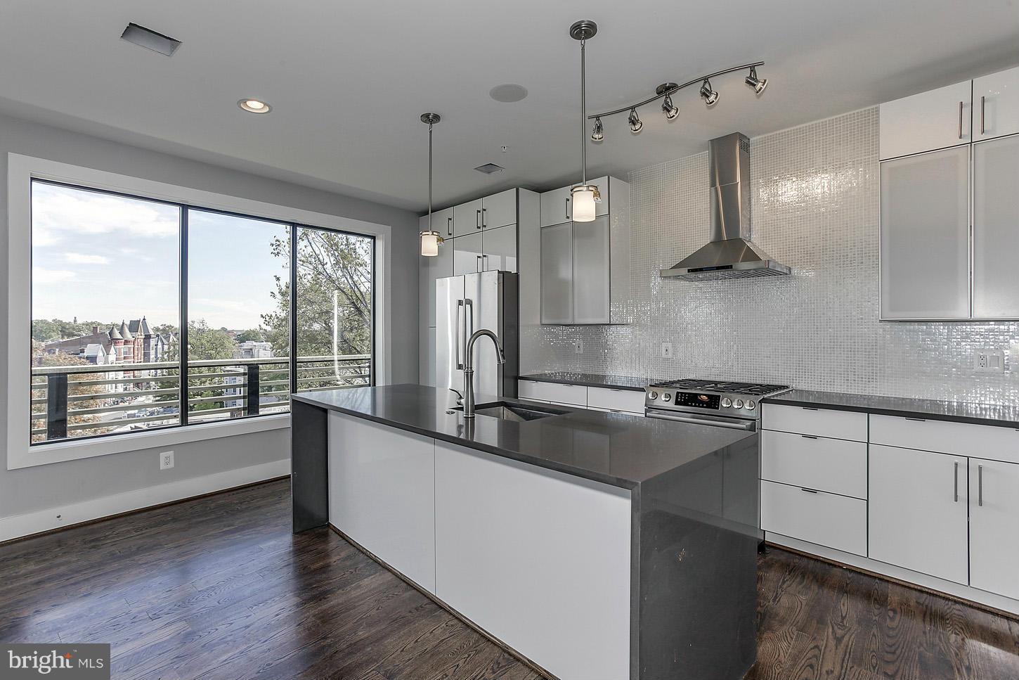 1839 6th Street Northwest, Unit 4 Washington, DC 20001 - Photo 20 of 29 a kitchen with granite countertop a sink a counter space stainless steel appliances and cabinets