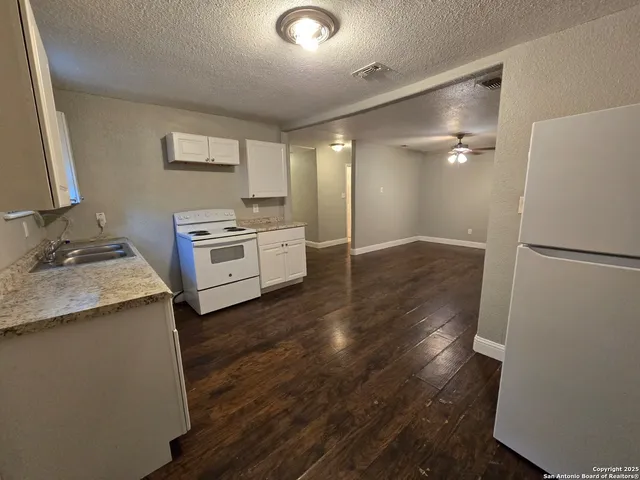 a kitchen with a refrigerator and a stove top oven