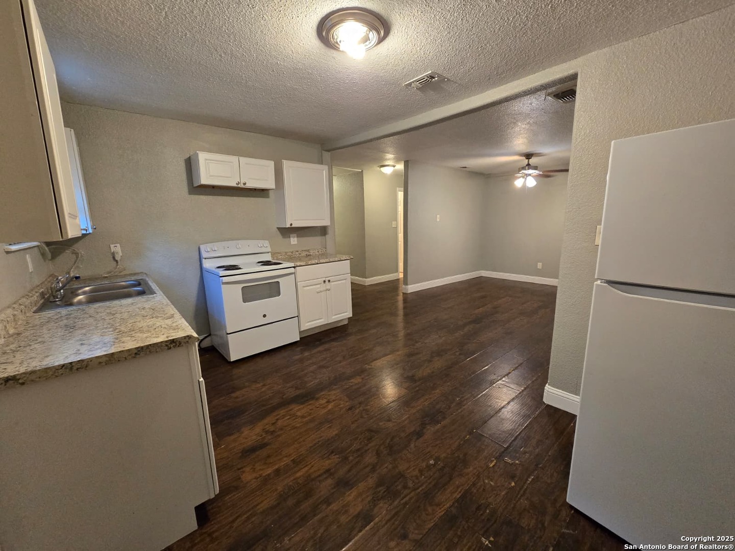 1718 Commercial, Unit B San Antonio, TX 78221 - Photo 1 of 13 a kitchen with a refrigerator and a stove top oven