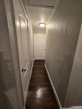 a view of a hallway with wooden floor