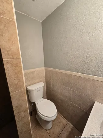 a white toilet sitting next to a shower