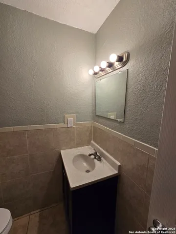 a bathroom with a sink toilet and a mirror