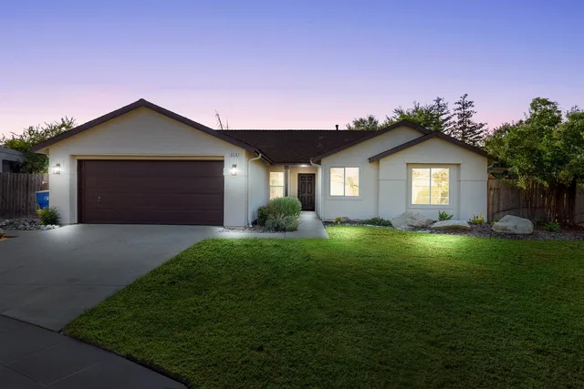 a front view of a house with a yard and garage