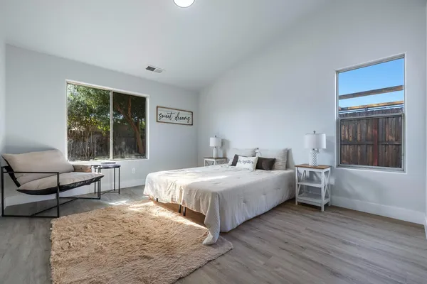 a bedroom with a large bed and wooden floor