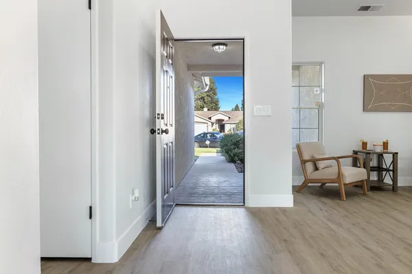 a view of a hallway to a livingroom and a dining room with furniture